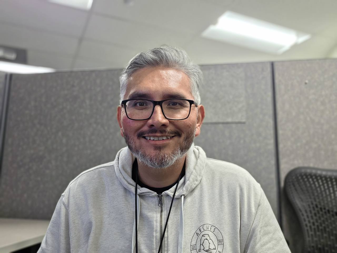Rudy Razo smiling at his desk